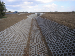 Zpevnění břehů a dna prvního úseku obtokového kanálu betonovými zatravňovacími tvárnicemi.JPG